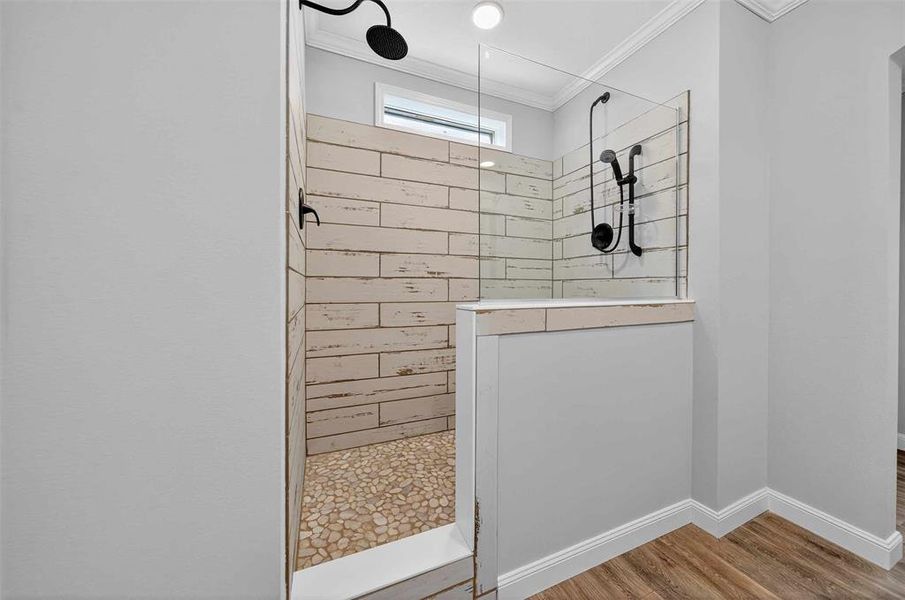 Bathroom with walk in shower, wood finished floors, and crown molding Bathroom with walk in shower, wood finished floors, and crown molding