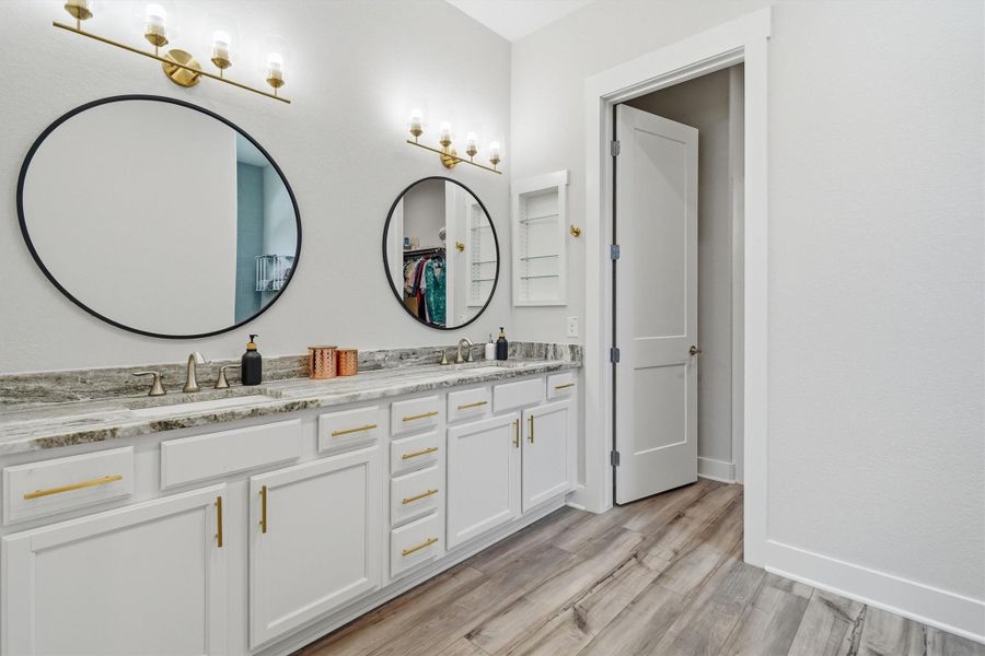 Primary en suite featuring double sinks, framed mirrors and tons of storage Primary en suite featuring double sinks, framed mirrors and tons of storage