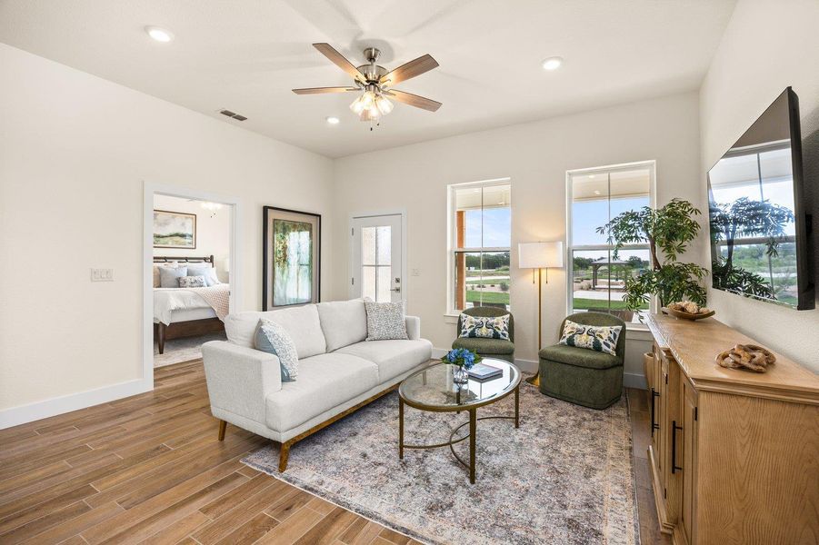 Living area featuring light wood-type flooring, a ceiling fan, and recessed lighting