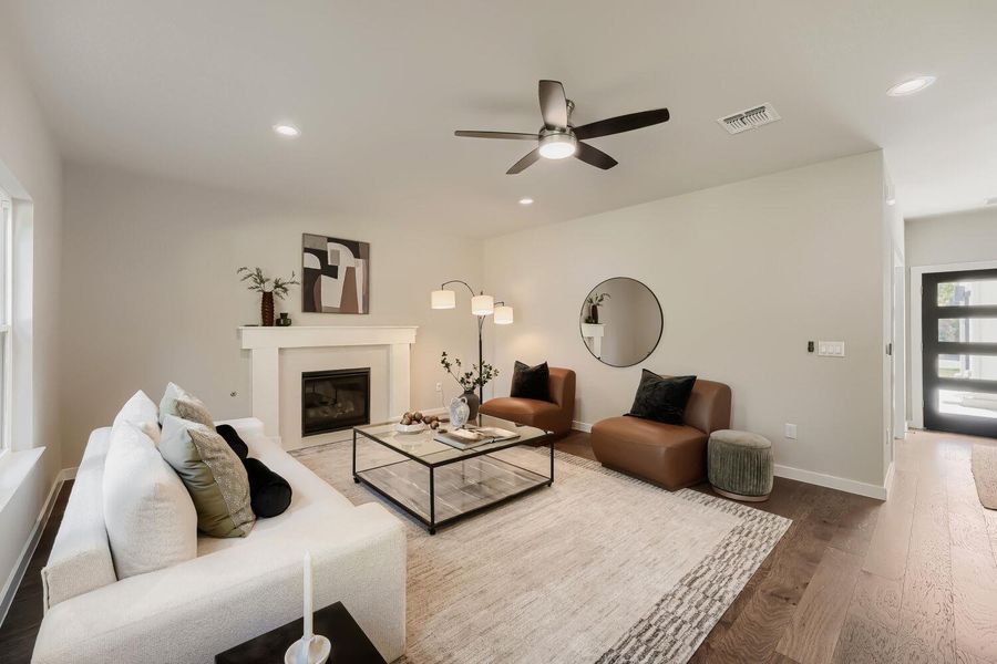 Hardwood floors complement the fireplace and recessed lighting in this well-appointed living room. Hardwood floors complement the fireplace and recessed lighting in this well-appointed living room.