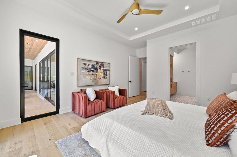 Bedroom with light wood-type flooring, access to exterior, recessed lighting, ensuite bathroom, and ceiling fan