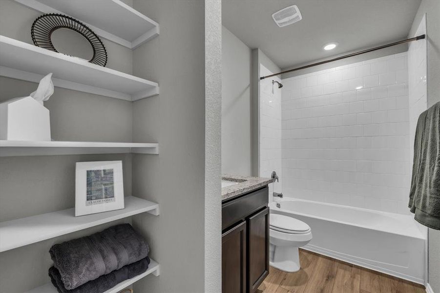 Hall bathroom serves bedroom 2 and bedroom 3; features generous shelves for storage.