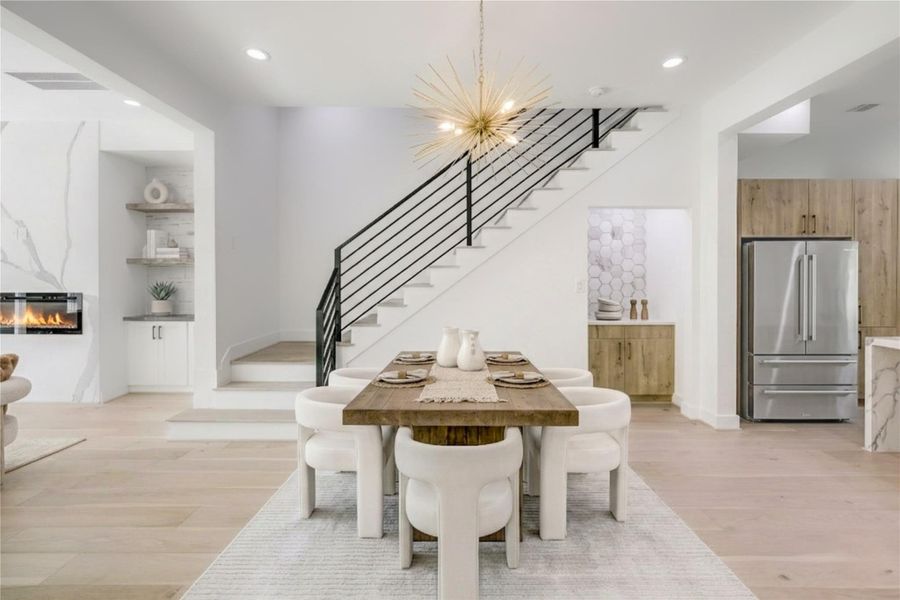 Dining - features a custom designer lighting fixture and a dry bar with quartz countertop.