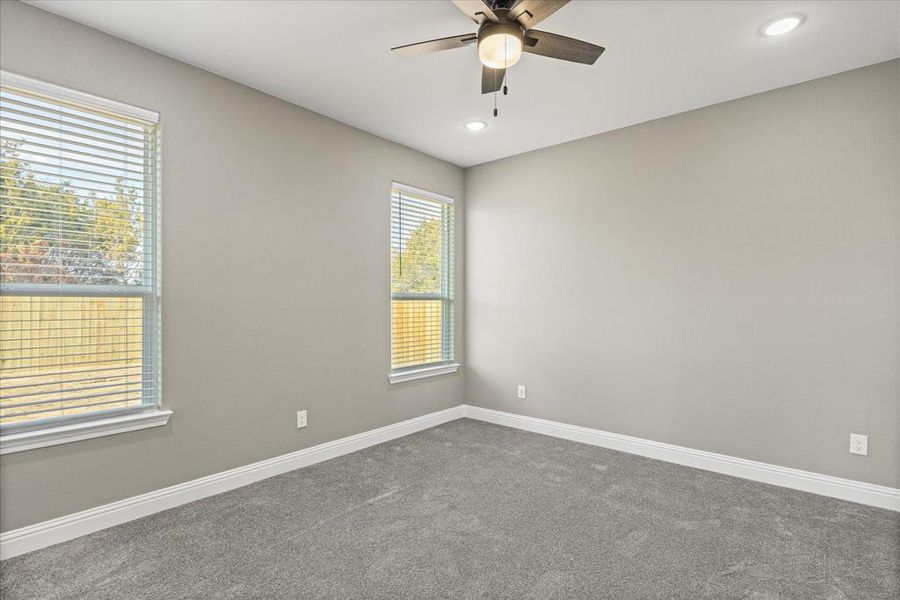 Primary BR with ceiling fan and carpet flooring