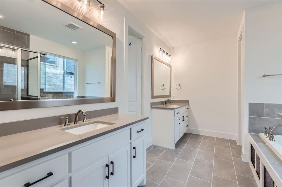 Bathroom featuring plus walk in shower, tile patterned flooring, and vanity