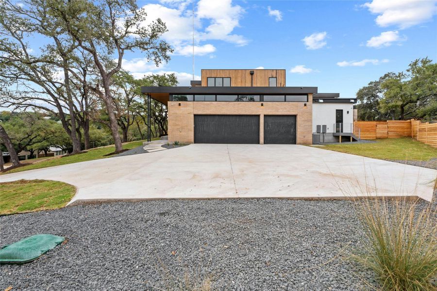 Three car side entry garage with wide apron for turning around and extra parking. Side fence leads into the back yard. Side door assesses the butler's pantry. Exterior construction is Douglas Fir, brick, stucco and break metal. Roof is TPO rubber.