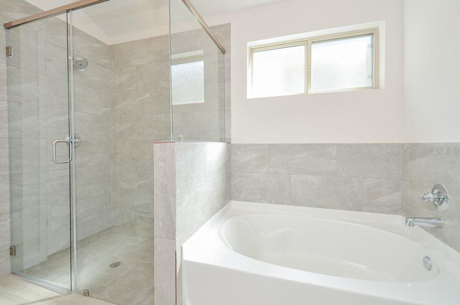 You have the choice to choose between a luxurious soaking bath, or a gorgeous glass-enclosed shower with a beautiful tile wall. You have the choice to choose between a luxurious soaking bath, or a gorgeous glass-enclosed shower with a beautiful tile wall.