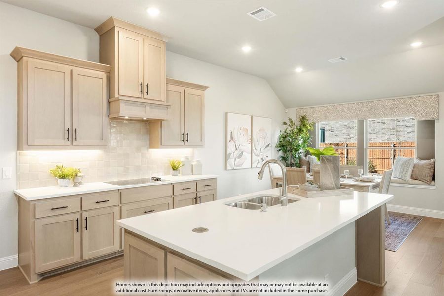 Kitchen with tan shaker cabinets, white island with sink, tile backsplash, and vaulted ceiling open to dining area