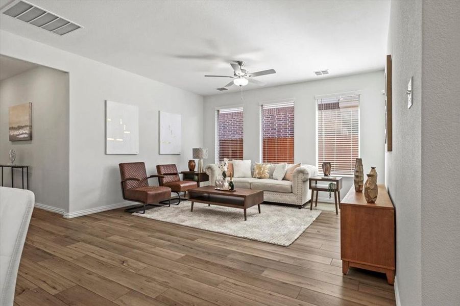Living area featuring wood finished floors and a ceiling fan Living area featuring wood finished floors and a ceiling fan