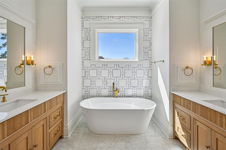 The primary bathroon features dual private reeded white oak vanities and a soaking tub set under awesome geometric pattern. Photo is taken from in front of the huge shower. This is an amazingly designed bathroom from a spatial perspective, perfectly symmetrical and stunning to be in. The primary bathroon features dual private reeded white oak vanities and a soaking tub set under awesome geometric pattern. Photo is taken from in front of the huge shower. This is an amazingly designed bathroom from a spatial perspective, perfectly symmetrical and stunning to be in.