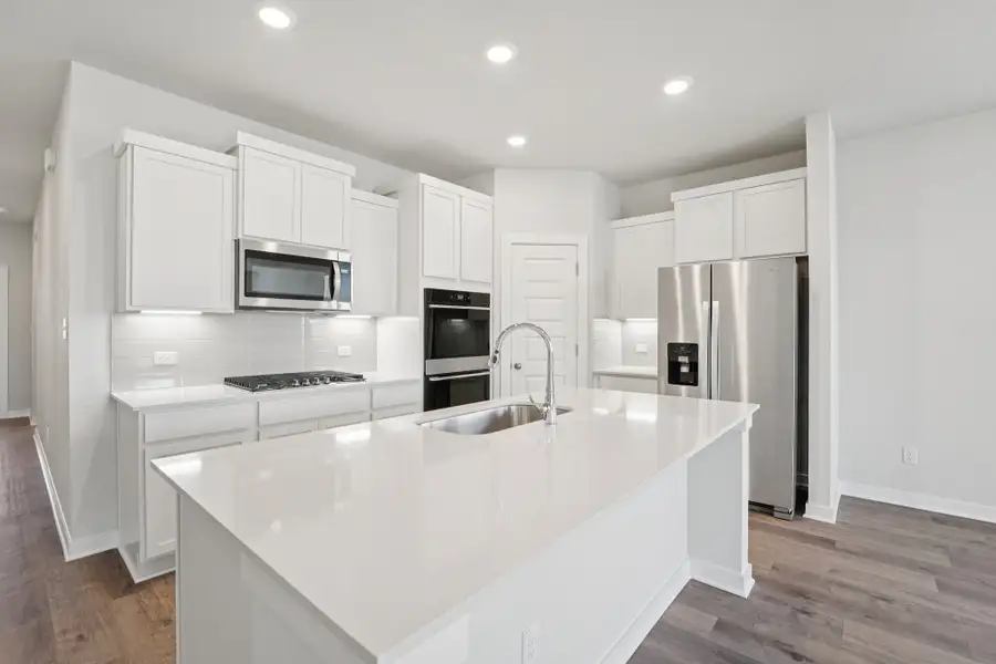 A kitchen with white cabinets.