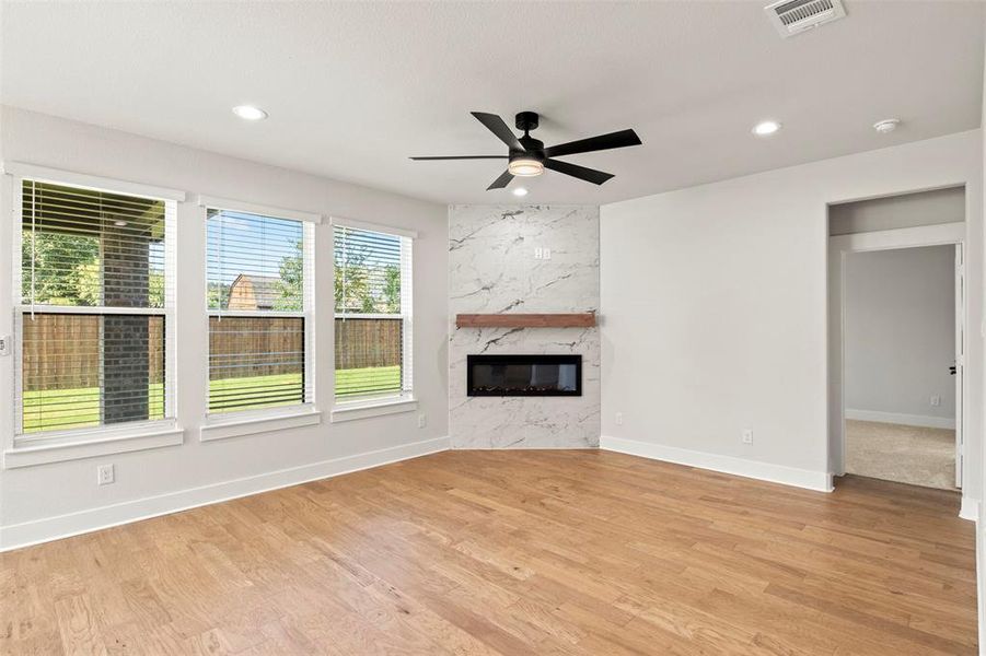 Unfurnished living room featuring recessed lighting, light wood-style flooring, a fireplace, and a ceiling fan