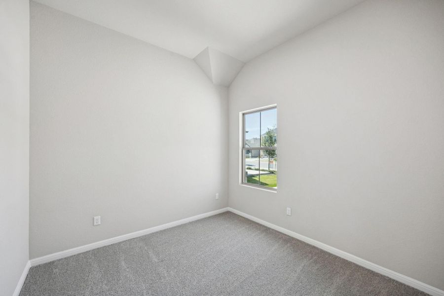 Spare room with carpet flooring and vaulted ceiling