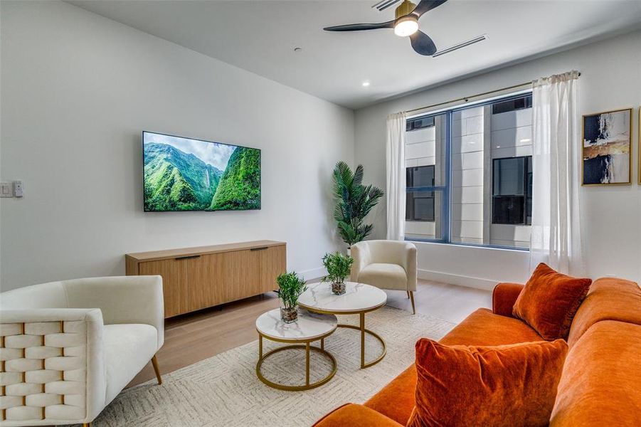 Model Home Sitting room with ceiling fan and wood finished floors