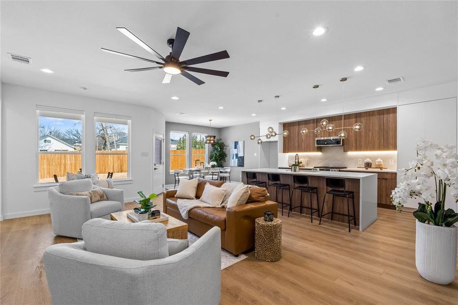 Living area with light wood-type flooring, ceiling fan, and recessed lighting Living area with light wood-type flooring, ceiling fan, and recessed lighting