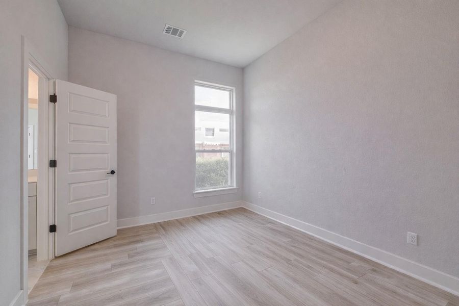 This room features light-colored flooring, a window providing natural light, and a white paneled door