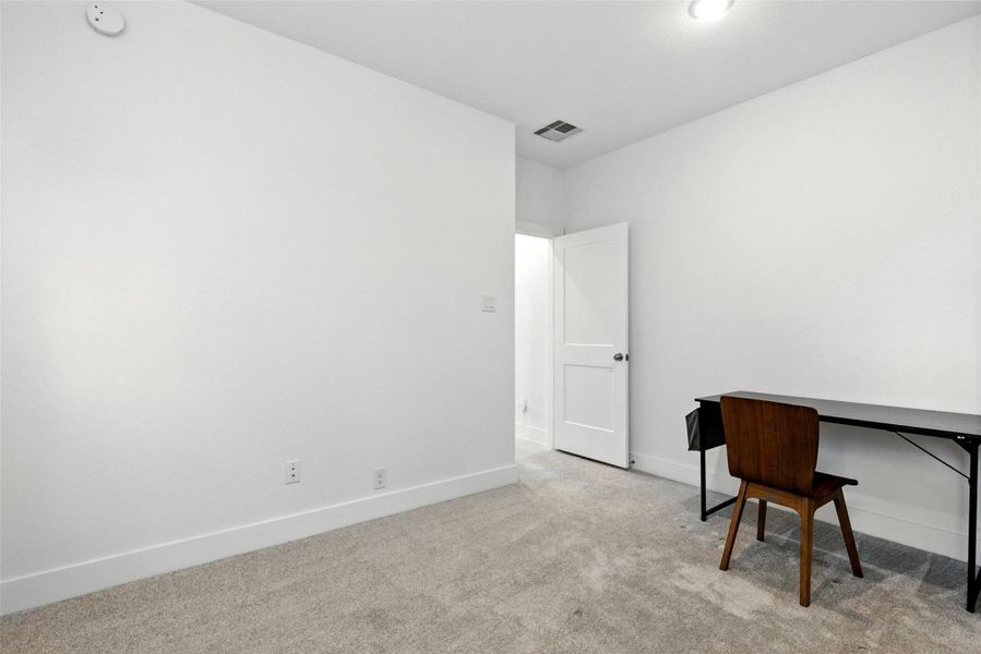 The secondary first floor bedroom features a largewindow and plush carpet. The secondary first floor bedroom features a largewindow and plush carpet.