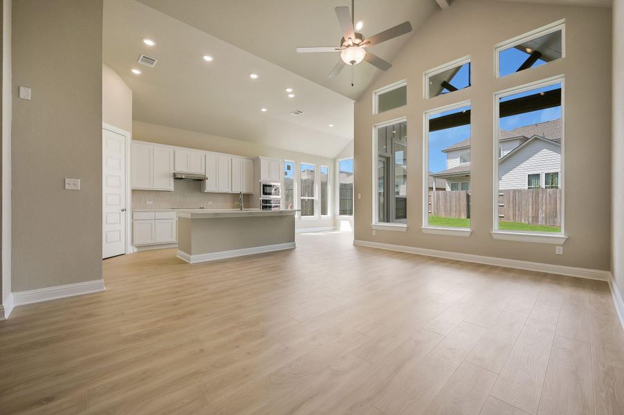 Unfurnished living room with recessed lighting, high vaulted ceiling, light wood finished floors, and ceiling fan