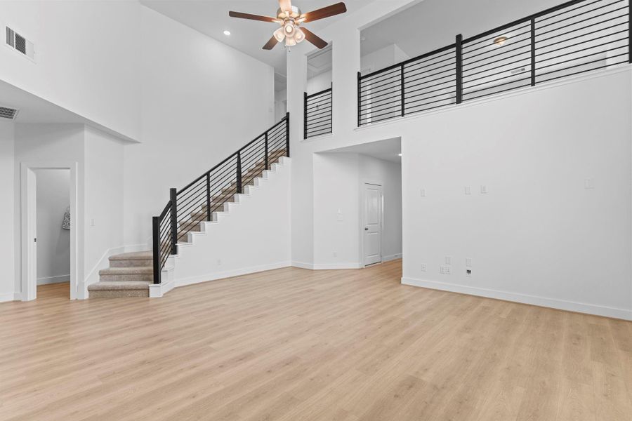 Modern wrought iron railing lines the sweeping staircase that curves gracefully from the main living space, drawing your eye upward and adding a sophisticated touch to the home’s open design. **Image Representative of Plan Only and May Vary as Built**.