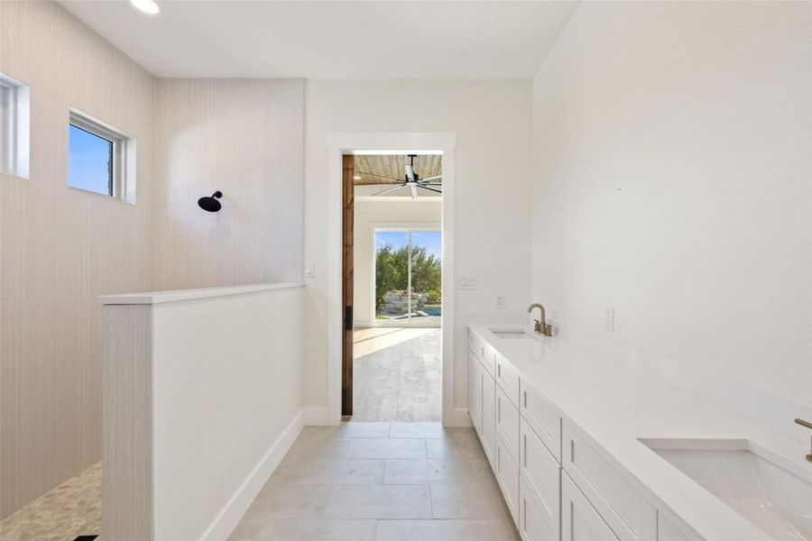 A sleek, contemporary bathroom with dual vanities and a spacious walk-in shower. A sleek, contemporary bathroom with dual vanities and a spacious walk-in shower.