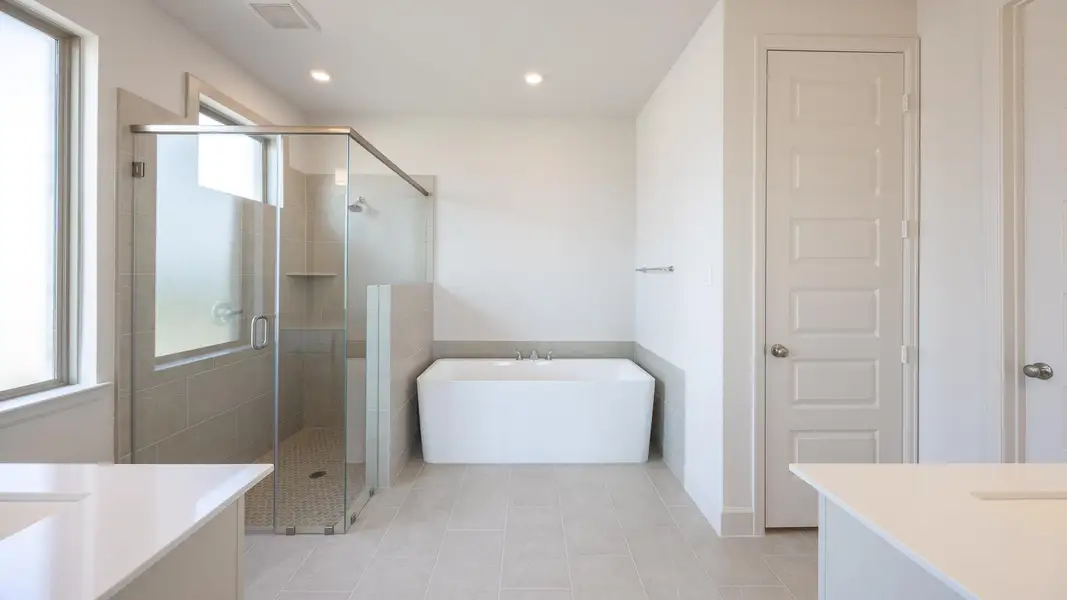 Full bathroom with vanity, a closet, a freestanding bath, a stall shower, and recessed lighting Full bathroom with vanity, a closet, a freestanding bath, a stall shower, and recessed lighting