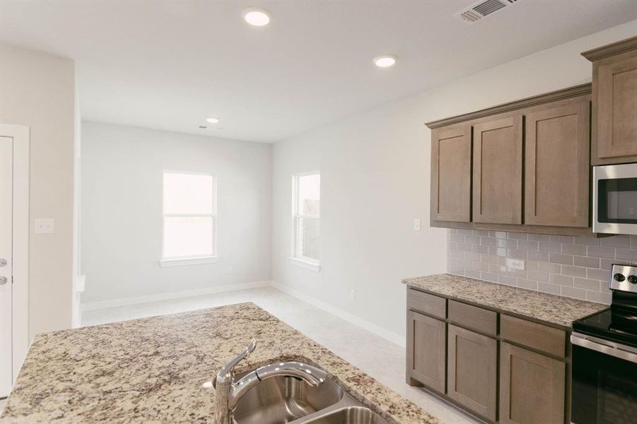 Kitchen with stainless steel appliances and backsplash