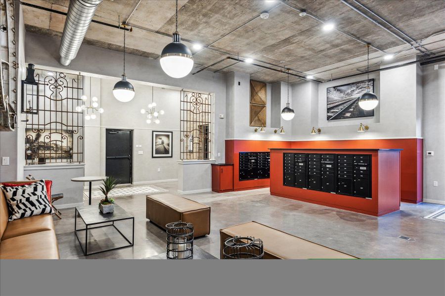 Industrial-chic lobby with exposed ductwork and concrete flooring, offering communal seating and secure mailboxes. Industrial-chic lobby with exposed ductwork and concrete flooring, offering communal seating and secure mailboxes.