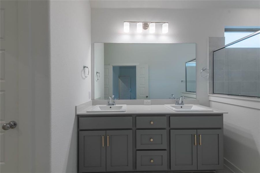Bathroom featuring double vanity and a shower
