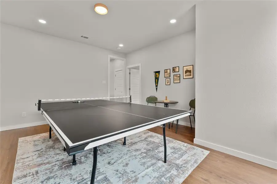 Recreation room with light wood-style floors and recessed lighting Recreation room with light wood-style floors and recessed lighting
