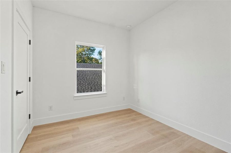 Unfurnished room with light wood finished floors and baseboards Unfurnished room with light wood finished floors and baseboards