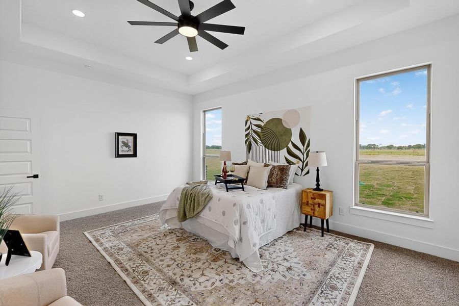 Carpeted bedroom with a tray ceiling, recessed lighting, and a ceiling fan