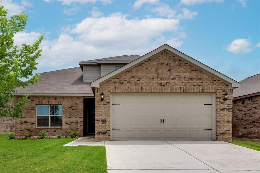 View of front of home featuring a front yard and a garage