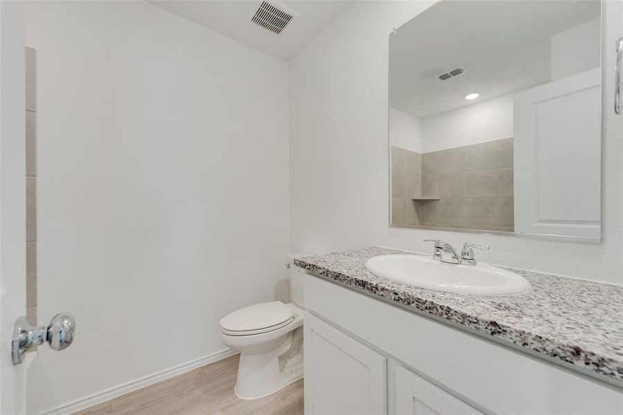 Bathroom with vanity, toilet, and wood-type flooring