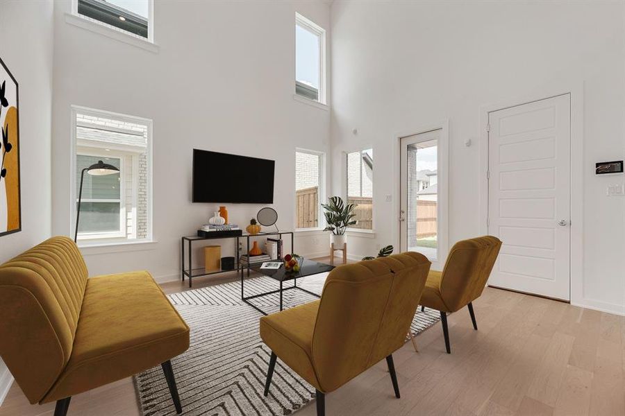 Living room with a towering ceiling and light wood-type flooring Living room with a towering ceiling and light wood-type flooring