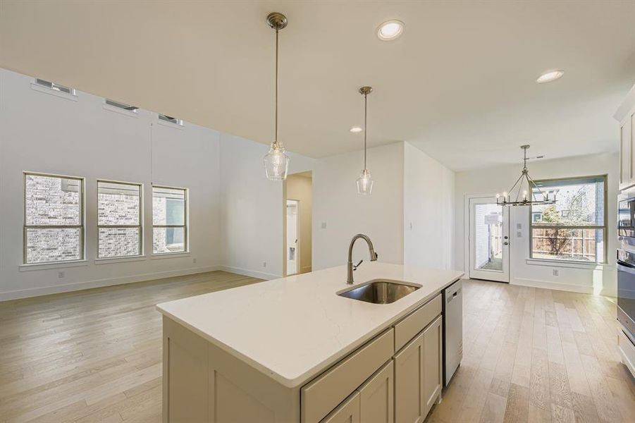 Kitchen with hanging light fixtures, a kitchen island with sink, recessed lighting, a chandelier, and light wood-style floors Kitchen with hanging light fixtures, a kitchen island with sink, recessed lighting, a chandelier, and light wood-style floors