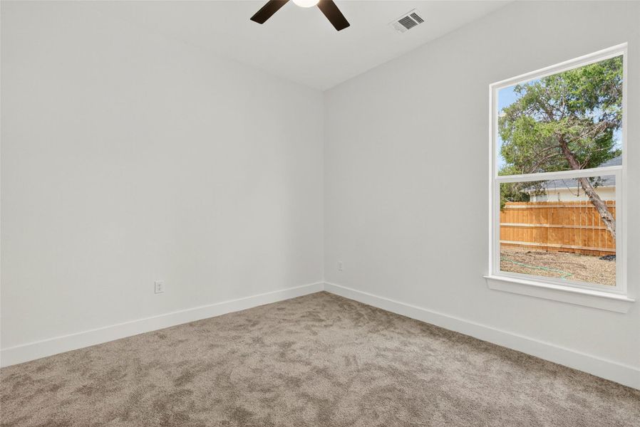 Empty room featuring carpet floors and a ceiling fan