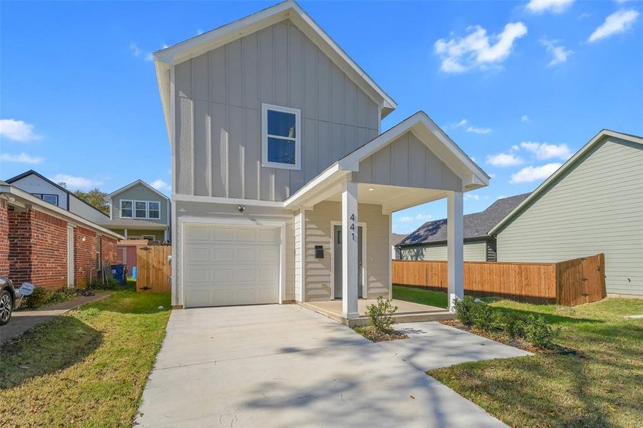 View of front of home featuring board and batten siding, driveway, covered porch, and an attached garage