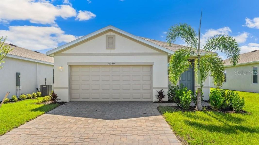 Front exterior of a new home in Coral Lakes - Tradition & Express, Punta Gorda, FL, highlighting curb appeal (Image 1). Front exterior of a new home in Coral Lakes - Tradition & Express, Punta Gorda, FL, highlighting curb appeal (Image 1).