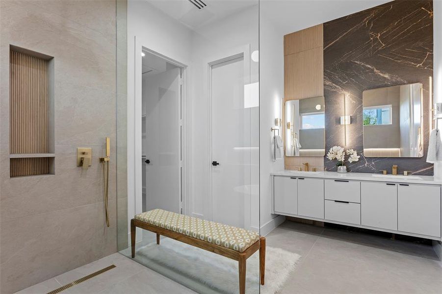 Bathroom with tile patterned floors, double vanity, and a tile shower