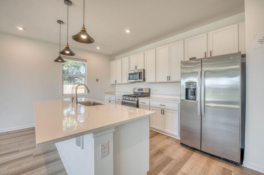Gleaming stone countertops and modern cabinetry define this open kitchen design.