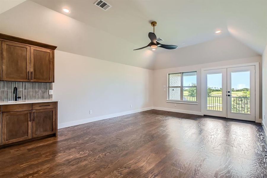 Unfurnished living room featuring vaulted ceiling, a ceiling fan, dark wood-style floors, french doors, and recessed lighting Unfurnished living room featuring vaulted ceiling, a ceiling fan, dark wood-style floors, french doors, and recessed lighting