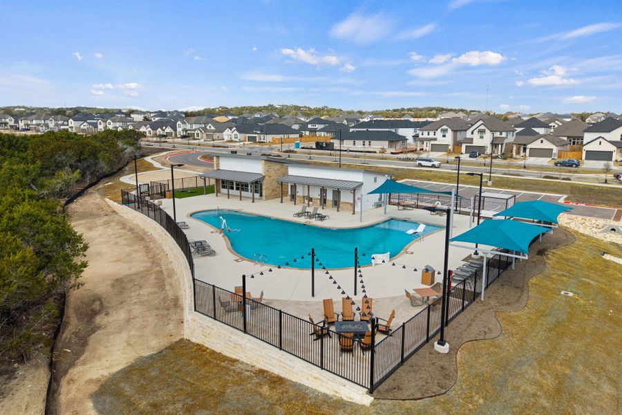 Community pool with a patio area and a residential view