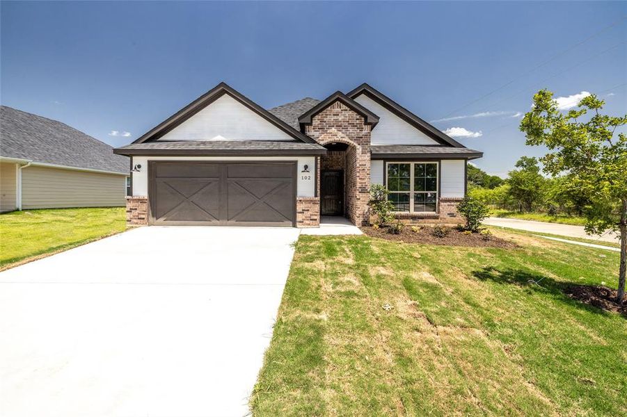 View of front of property featuring a garage and a front yard