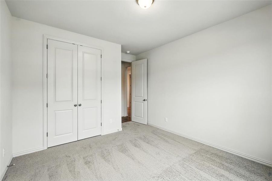 Unfurnished bedroom featuring light colored carpet and a closet