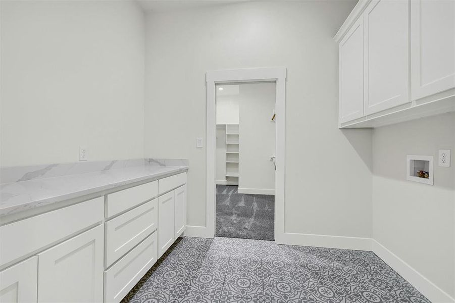 Laundry area featuring hookup for a washing machine, cabinets, and tile patterned flooring