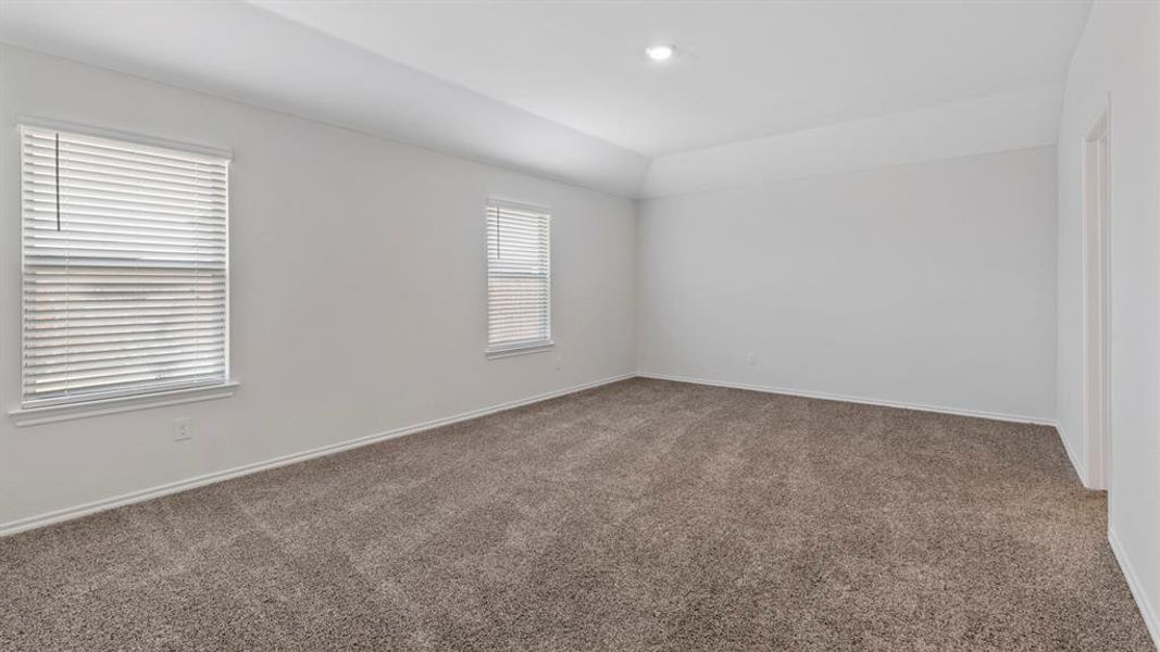 Carpeted spare room featuring baseboards