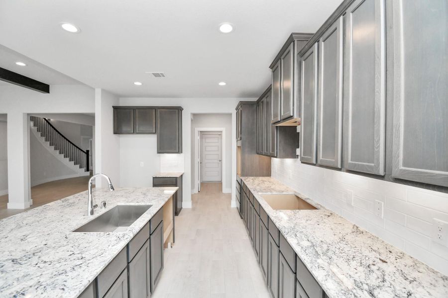 The extended counter area adds both practicality and style, making meal preparation a breeze. Every detail is thoughtfully designed to enhance the kitchen's functionality and aesthetic appeal. Sample photo of completed home with similar floor plan. Actual colors and selections may vary.