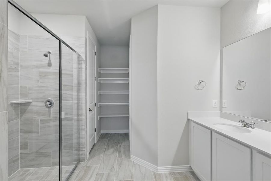 Full bath featuring a stall shower and vanity