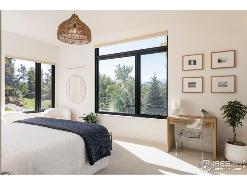 A private wing offers a powder room, a guest bedroom, and a generous suite with a walk-in closet, en suite bath, and direct access to a west-facing patio framed by sweeping Front Range vistas. A private wing offers a powder room, a guest bedroom, and a generous suite with a walk-in closet, en suite bath, and direct access to a west-facing patio framed by sweeping Front Range vistas.