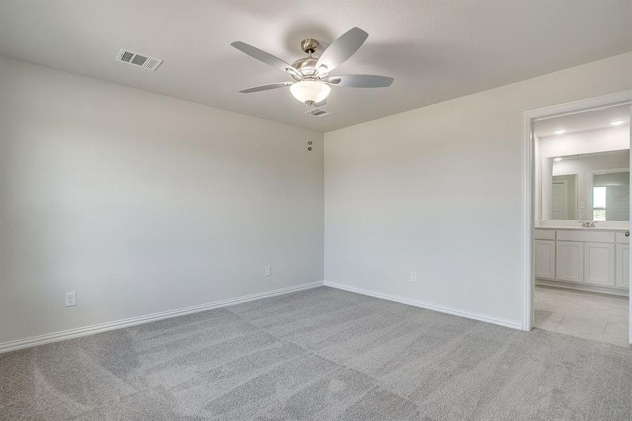 Spare room featuring light colored carpet and a ceiling fan